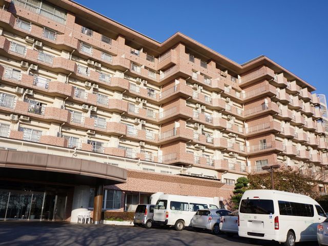 エントランスが見える建物 駐車場 広々としたエントランスが印象的な建物で、明るい雰囲気が漂っています。多くの部屋があり、働く環境としても多彩な経験ができそうです。
