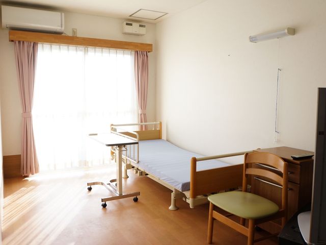 明るい個室と日差し 居室 陽光が差し込む暖かな個室です。ベッドとテーブルが整い、快適な時間を過ごせる環境が整っています。