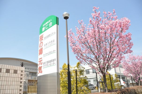 施設の看板と桜