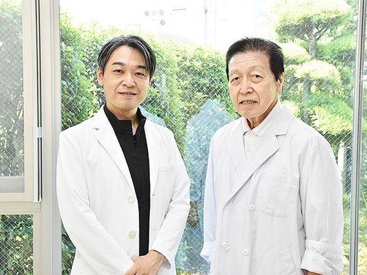 白衣の男性2人が窓辺に立つ内観  