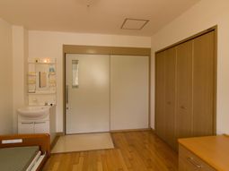 居室の洗面台とベッド