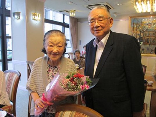 笑顔のご夫婦と花束