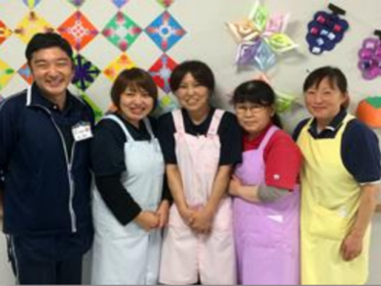 スタッフ5人が並ぶ多目的室  