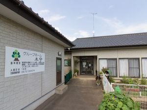 外壁と緑の標識の施設外観