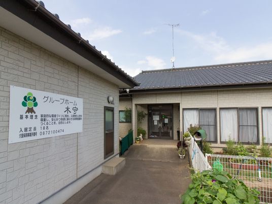外壁と緑の標識の施設外観