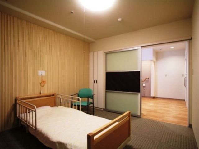 居室内のベッドと椅子 居室 広々とした居室です。機能的な家具と優しい照明が心地よい空間を演出しています。