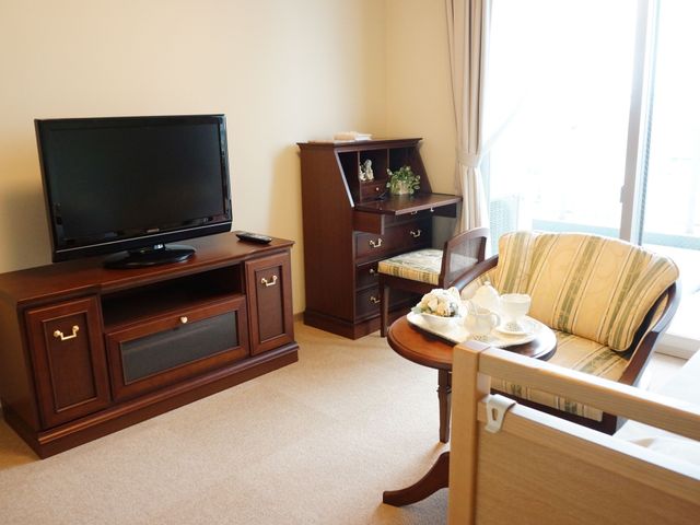 快適な洋室の一角 居室 床から天井まで自然光が差し込む居室で、ゆったりとしたソファが設置されています。個々のリラックスタイムを大切にされたい方におすすめです。
