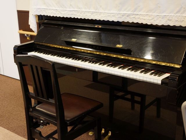 黒いピアノと椅子 ピアノ 皆で楽しめる楽器のある居心地の良いラウンジです。音楽を通じてのコミュニケーションがはかれます。