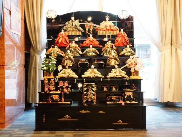 多層飾りの雛人形 ひな人形 伝統的な雛祭りの飾りがロビーに展示され、季節の行事が彩りを加えています。職場での特別な日々を一緒に楽しむことができます。