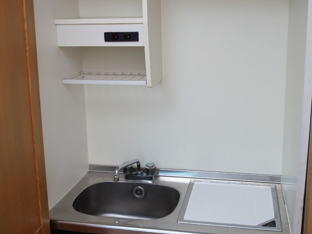 コンパクトなキッチン一角 ミニキッチン 整理整頓しやすいシンプルなキッチンで、快適な料理空間を提供します。