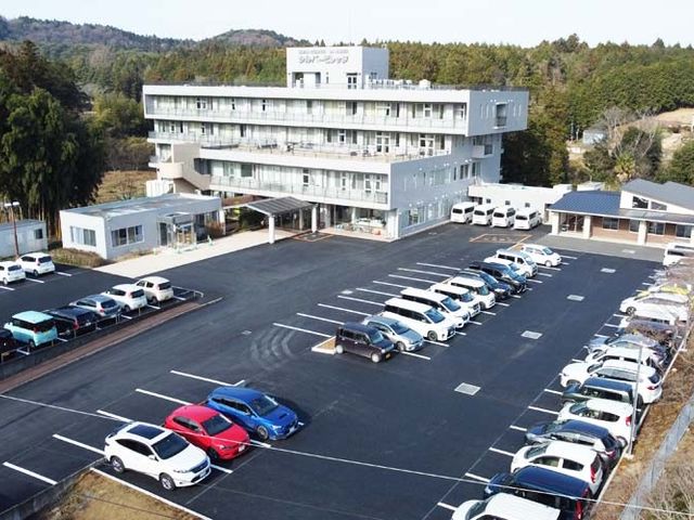 広い駐車場の外観 外観 豊かな自然に囲まれた建物の外観は、周囲の環境と調和しています。広い駐車スペースも完備しています。