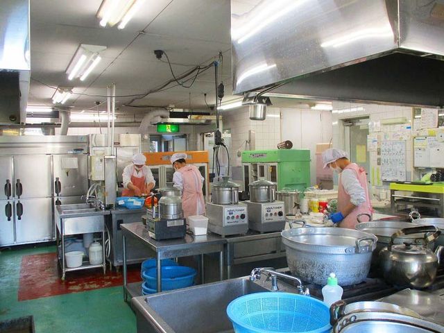 調理中のキッチン キッチン 明るいキッチンでスタッフが作業しています。設備が整った環境で効率的に調理可能です。