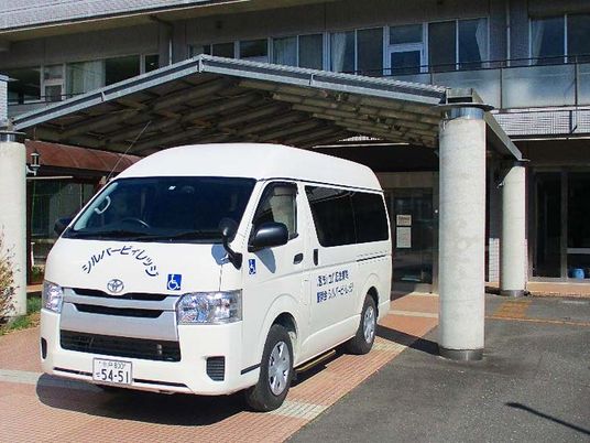 送迎車と玄関外観  