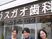 笑顔のスタッフと看板外観  