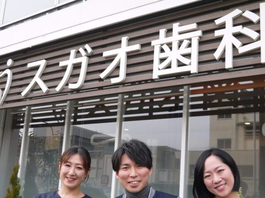 笑顔のスタッフと看板外観  