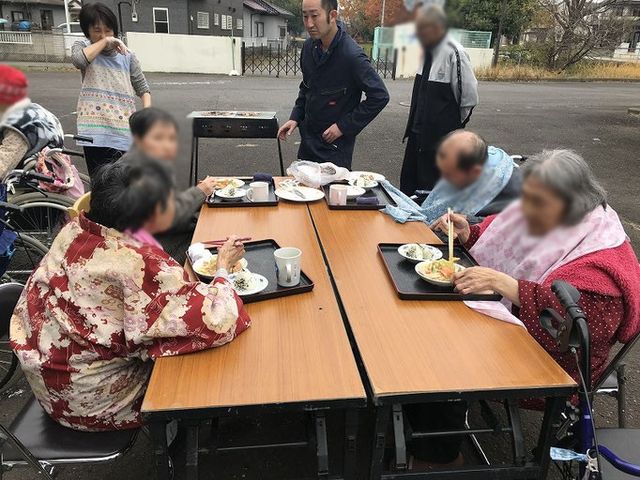 交流の場、庭 庭 屋外で楽しく団欒している様子です。スタッフも参加し、会話を楽しんでいます。