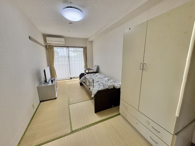 静かな一人部屋 居室 自然光がたっぷり注ぐ静かな空間です。家具が整然と配置され、落ち着けるひとときを過ごせます。