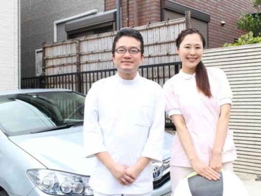 スタッフ2人が車の前に立つ外観  