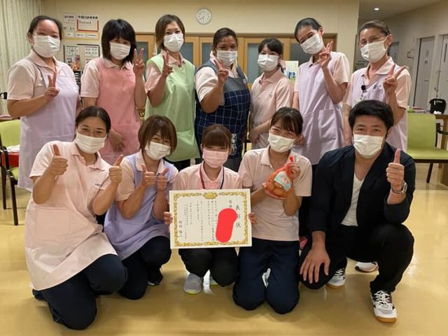 スタッフ集合写真 スタッフイメージ 笑顔でポーズを取るスタッフ一同の元気な姿です。安心してお過ごしいただける環境がここにあります。