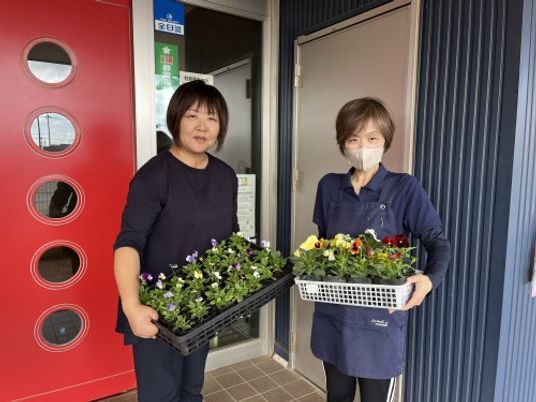 スタッフが花苗を持つエントランス  
