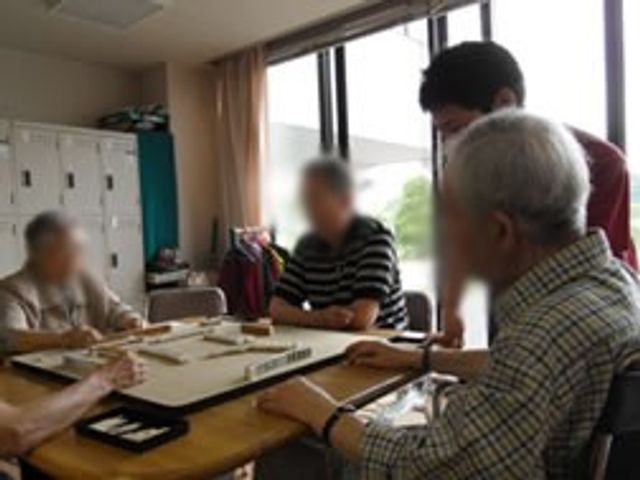 ゲームを楽しむ人々の様子 多目的室 自然光が差し込むスペースで、リラックスした雰囲気の中、皆でゲームを楽しんでいます。