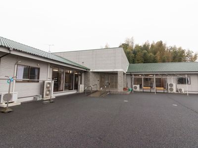 白い壁の建物と駐車場