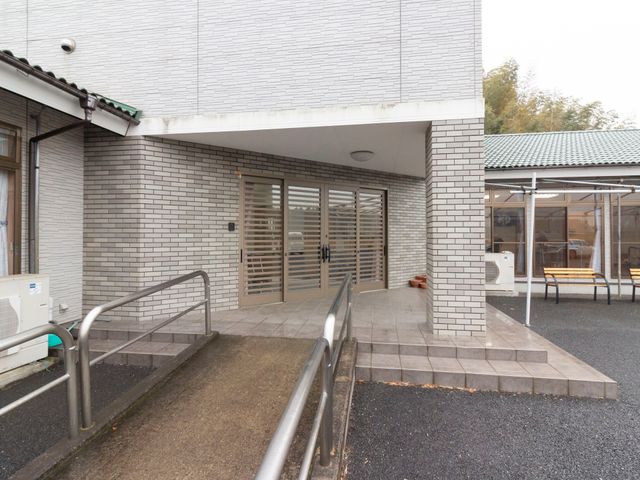 エントランスの外観 玄関  手すり付のスロープが設けられたエントランスは、どなた様も安全にご利用いただけるバリアフリー設計です。