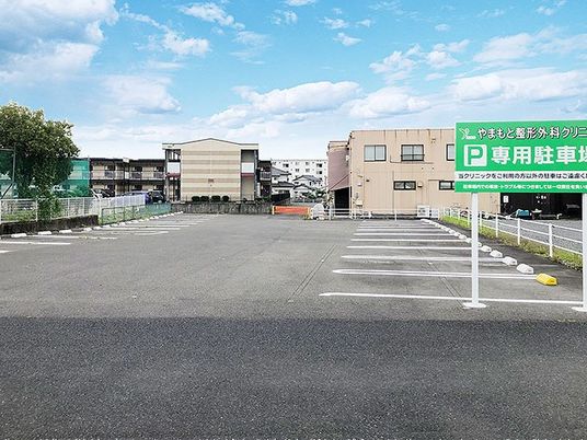 広い駐車場と案内看板の外観  