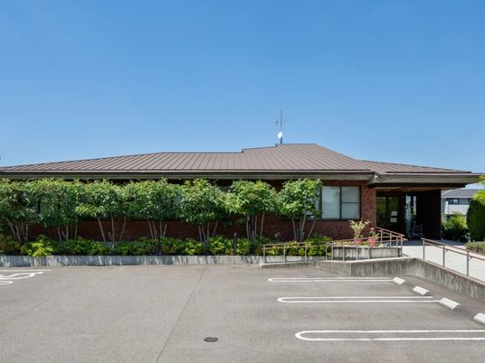 緑に囲まれた平屋の外観  