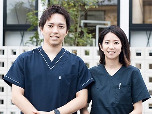 スタッフの男女二人が並ぶ外観前  