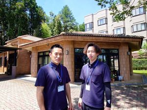 職員2人と建物外観  