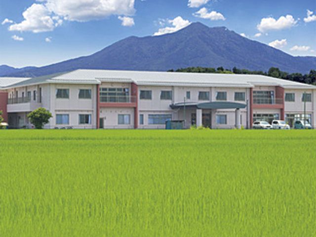 山が背景の建物外観 外観 山を望む爽やかな環境に位置しており、自然を感じながら働けます。快適な職場です。