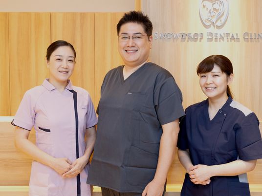笑顔のスタッフ3人が並ぶ受付前  