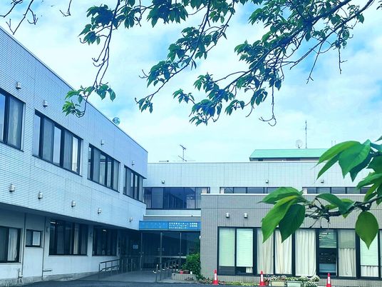緑に囲まれた建物の外観  