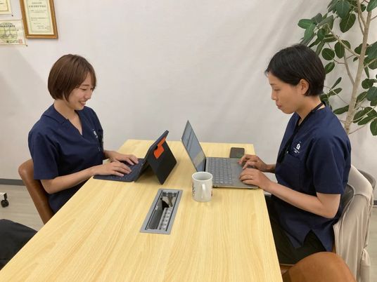 スタッフが机で作業する休憩室  
