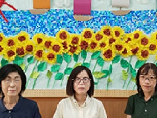 花飾り前の職員3人  