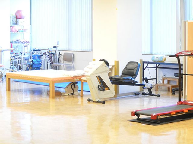 明るい機能訓練室 機能訓練室 広々とした機能訓練室では、さまざまな器具を使って、日常生活の動作向上をサポートします。明るい雰囲気の中で、リハビリに取り組む様子が見受けられます。