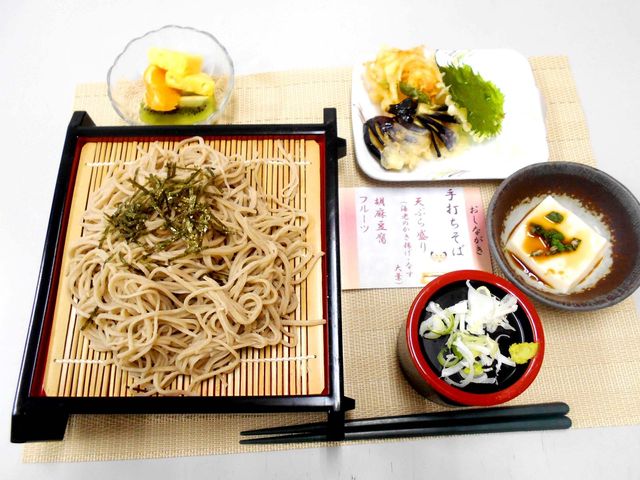 料理の盛り付け 料理 手打ちそばと豊富なおかずが並んだ食事です。様々な味を楽しめるよう工夫されています。