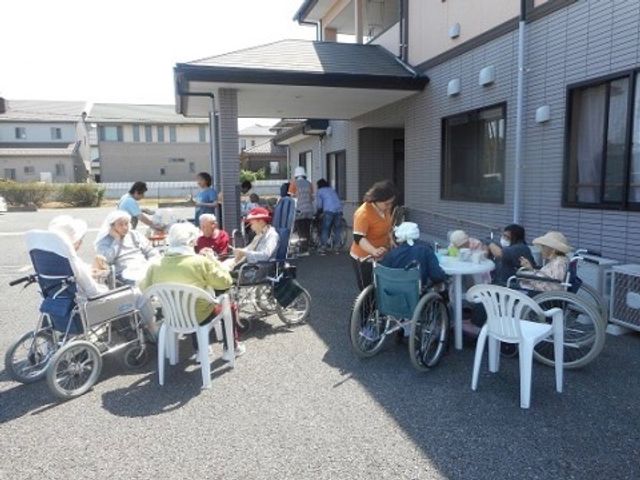 日差しの中のひととき バーベーキュー大会 穏やかな日差しを感じられる中庭で、利用者様が心地よい時間を過ごされています。外での活動が就業のやりがいにつながります。
