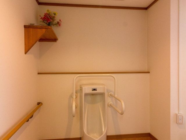 バリアフリー設計のトイレ トイレ 手すり付きで安全に配慮された清潔感のあるトイレ空間です。利便性と快適性を備え、働く環境への配慮が感じられます。