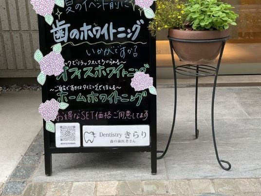 案内看板と鉢植えのある玄関先  