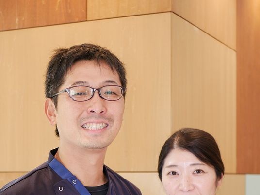 笑顔のスタッフ2人と壁面  