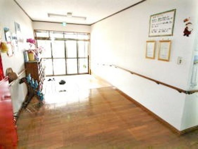 広々とした明るい廊下 玄関 手すり付きの廊下は、安全に移動ができるよう配慮された設計です。壁に掲示された案内も見やすく工夫されています。