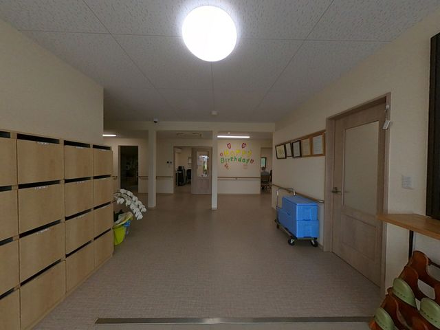 安心の空間 廊下 エントランス 広々とした廊下は明るく、壁にはあたたかみのある飾りがあります。ご利用者の皆様の安全な移動をサポートします。