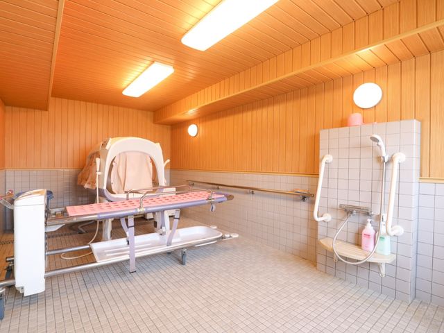 快適な介護用浴室 機械浴室 木目調で温かみのある浴室です。安全に配慮された手すりや広々としたスペースが整っており、利用者の快適な入浴を支えています。