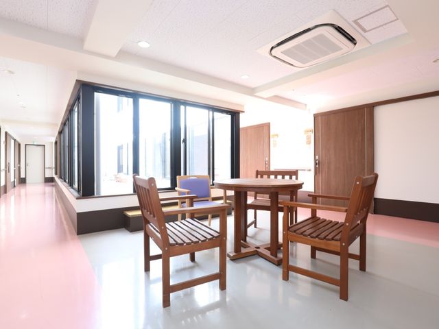 共有スペースのゆったりした様子 廊下 床が光る明るい共有スペースで、くつろぎながらお仕事ができます。窓際に設置されたテーブルには、座って対話を楽しむことも可能です。