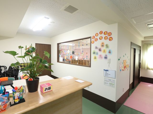 色とりどりの壁飾りのエントランス 保育園 明るく暖かい雰囲気の受付エリアです。壁にはカラフルな装飾が施され、訪れる人をやさしく迎えます。