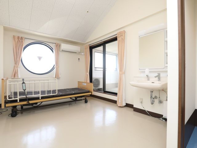 明るい病室のベッドエリア 居室 ゆったりとした居室には、必要な設備が整い、窓からは自然光が差し込む落ち着いた空間です。効率的な配置で、快適な仕事環境を提供しています。