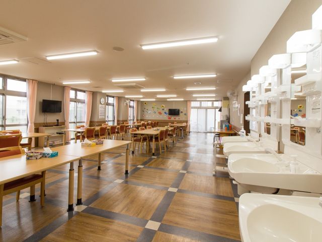 広々とした食堂スペース 日常の様子 床のチェック柄が印象的な食堂では、テレビを観ながらゆったりとした時間を過ごせます。明るく清潔感のある環境でのご就業をお考えの方はぜひお越しください。