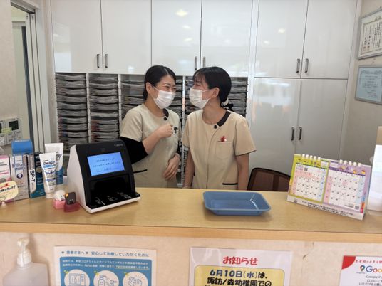笑顔のスタッフが受付で会話するフロント  